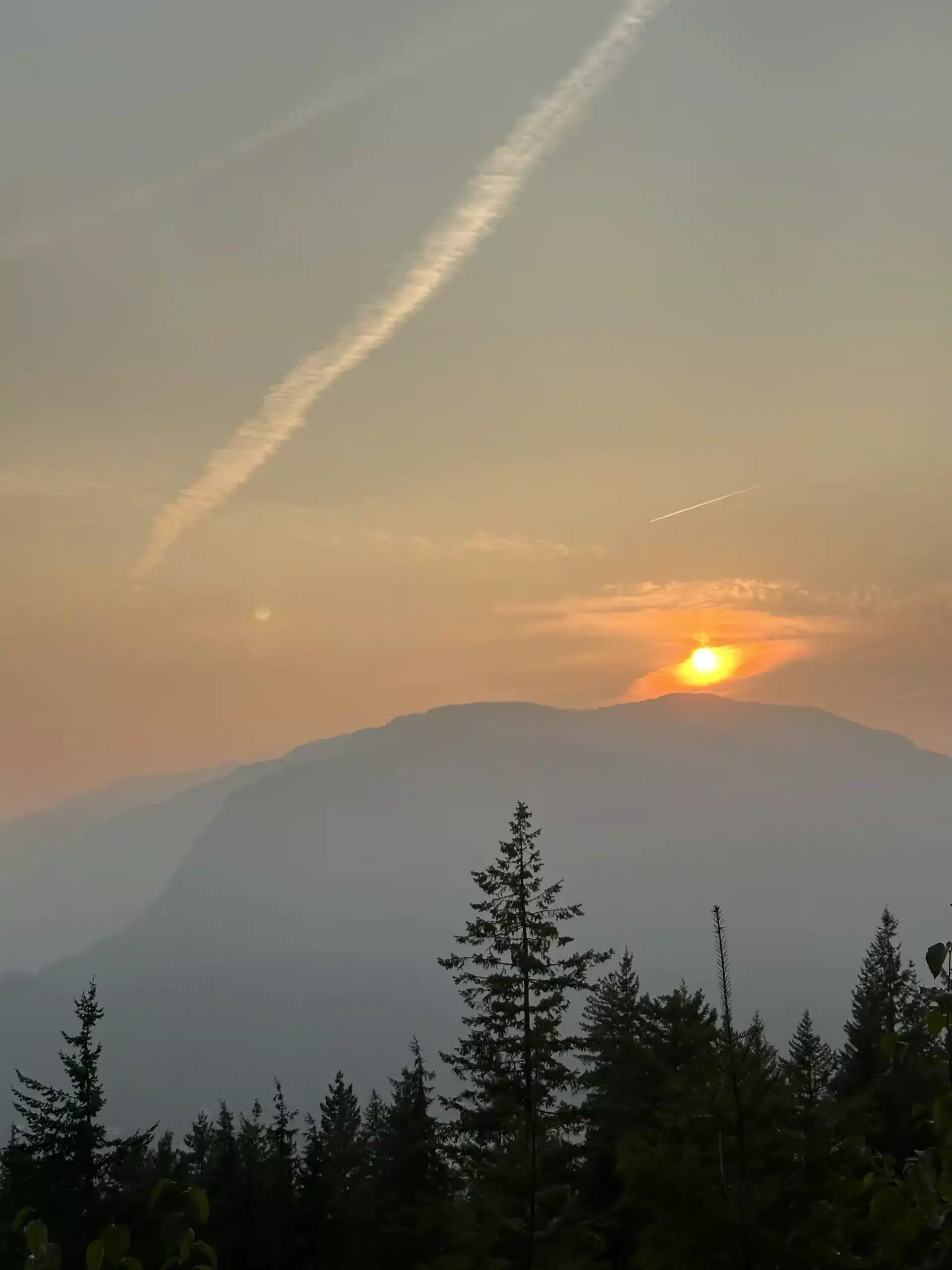 A beautiful hazy sunset over the mountains on a drive from Vancouver to the Canadian Rockies